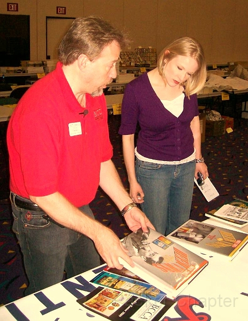 14.JPG - Pat shows Alison the various beer can books the BCCA has produced.